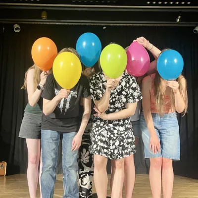 Gruppenbild mit Ballons vor den Gesichtern